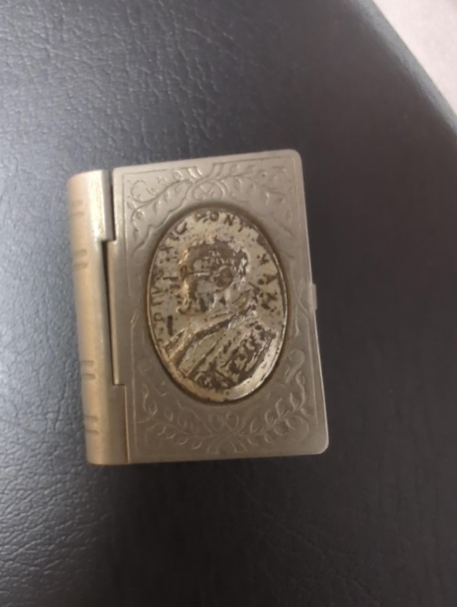 An Edwardian silver miniature model of an occasional chair, import marks for London, 1902, 43mm, a continental white metal model of a shoe and a similar model of a young child, a base metal 'book' box containing a rosary